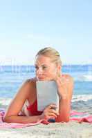 Adorable woman reading a book on the beach
