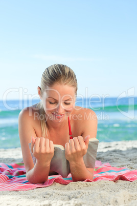 Adorable woman reading a book on the beach