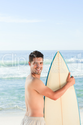 Handsome man beside the sea with his surfboard