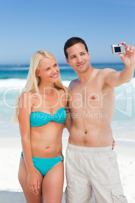 Couple taking a photo of themselves on the beach