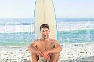Handsome man beside the sea with his surfboard