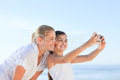 Little girl taking a photo of herself and her mother