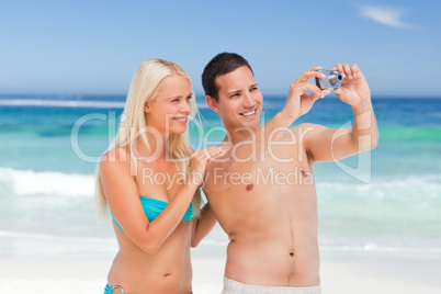 Couple taking a photo of themselves on the beach