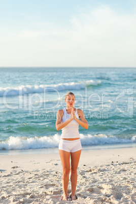 Woman practicing yoga on the beach