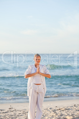 Woman practicing yoga on the beach