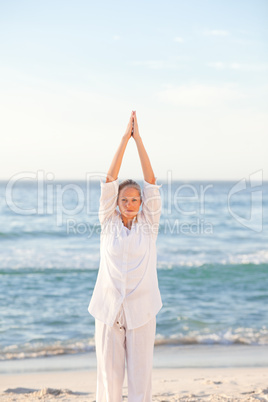 Woman practicing yoga at the beach