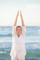 Woman practicing yoga at the beach
