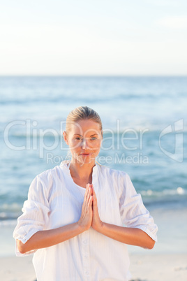 Woman practicing yoga at the beach