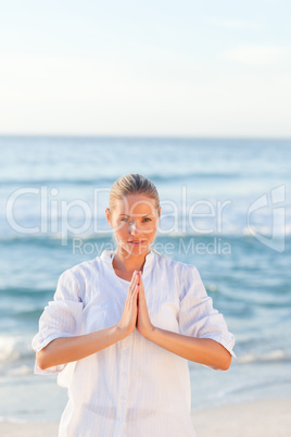 Active woman practicing yoga on the beach