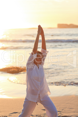 Woman practicing yoga during the sunset