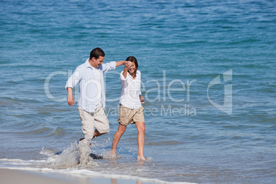 Couple walking on the beach under the sun