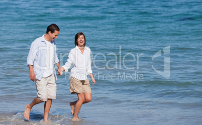 Couple walking on the beach under the sun