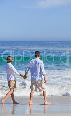 Couple walking on the beach under the sun