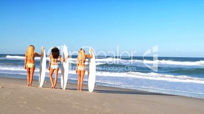 Drei Mädchen mit Surfbrettern
