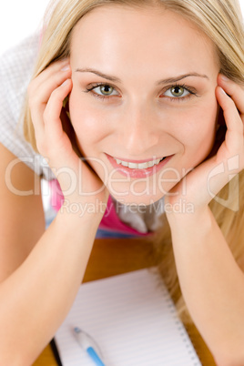 Happy student woman write homework at table