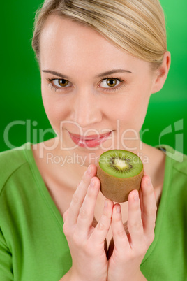 Healthy lifestyle - happy woman holding kiwi on green