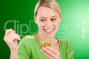 Healthy lifestyle - happy woman holding kiwi and teaspoon