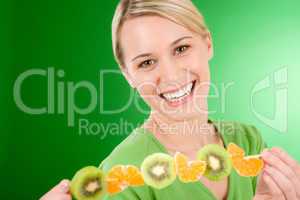 Healthy lifestyle - woman eating kiwi and orange