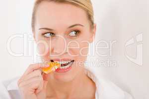 Healthy lifestyle - portrait of woman bite slice of tangerine