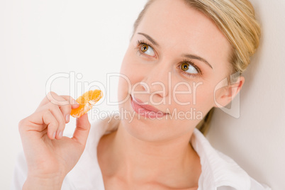 Healthy lifestyle - portrait of woman holding tangerine slice