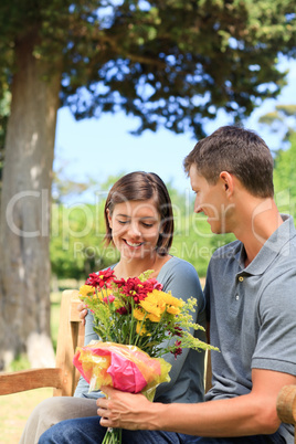 Young man offering flowers to his girlfriend