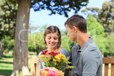 Young man offering flowers to his girlfriend