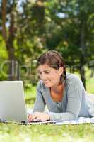 Woman working on her laptop in the park