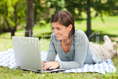 Woman working on her laptop in the park