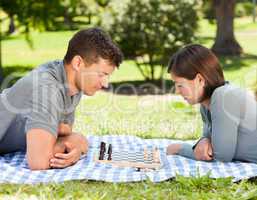 Couple playing chess in the park