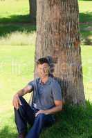 Man sitting beside a tree