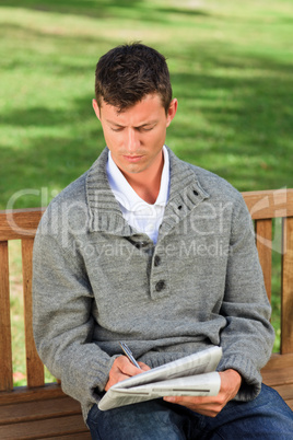 Handsome man making his crossword