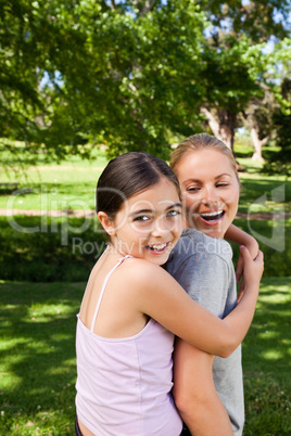 Mother and her daughter laughting in the park