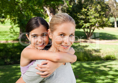Mother and her daughter laughting in the park