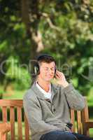 Young man listening to some music on the bench