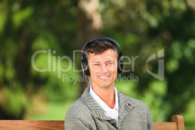 Young man listening to some music on the bench