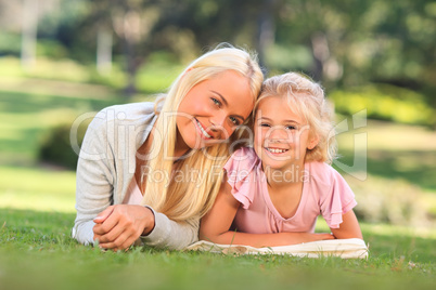 Mother with her daughter lying down in the park