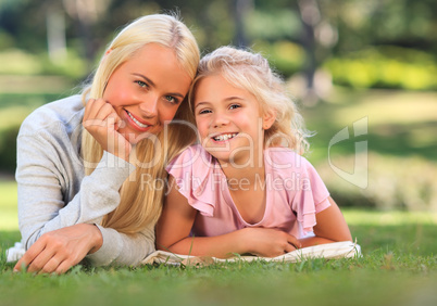 Mother with her daughter lying down in the park