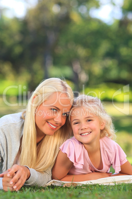 Mother with her daughter lying down in the park