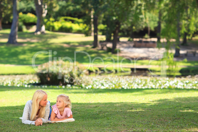 Mother with her daughter lying down in the park