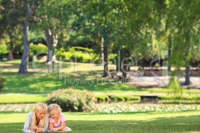 Mother with her daughter lying down in the park