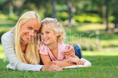Mother with her daughter lying down in the park