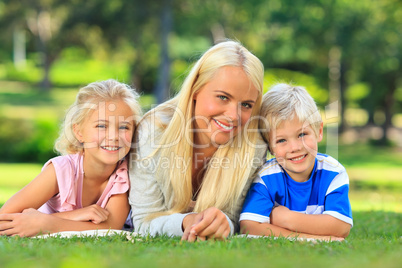 Mother with her children lying down in the park