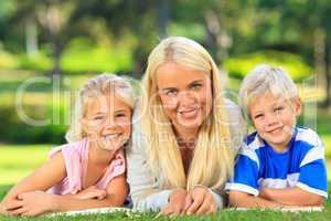 Mother with her children lying down in the park