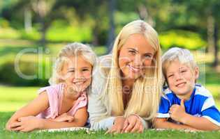 Mother with her children lying down in the park