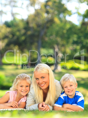 Mother with her children lying down in the park