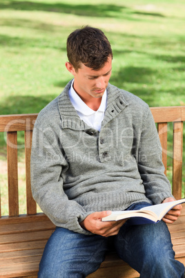 Man reading his book on the bench