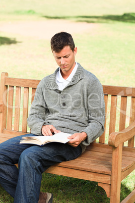 Man reading his book on the bench