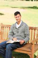 Man reading his book on the bench