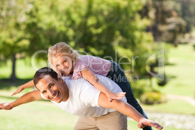 Little girl playing with her father in the park