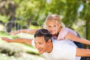 Little girl playing with her father in the park